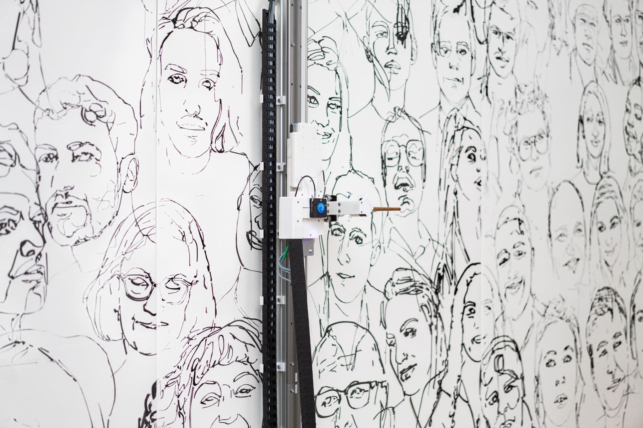 A calligraphic brush powered by a mechanised armature captures people's portraits