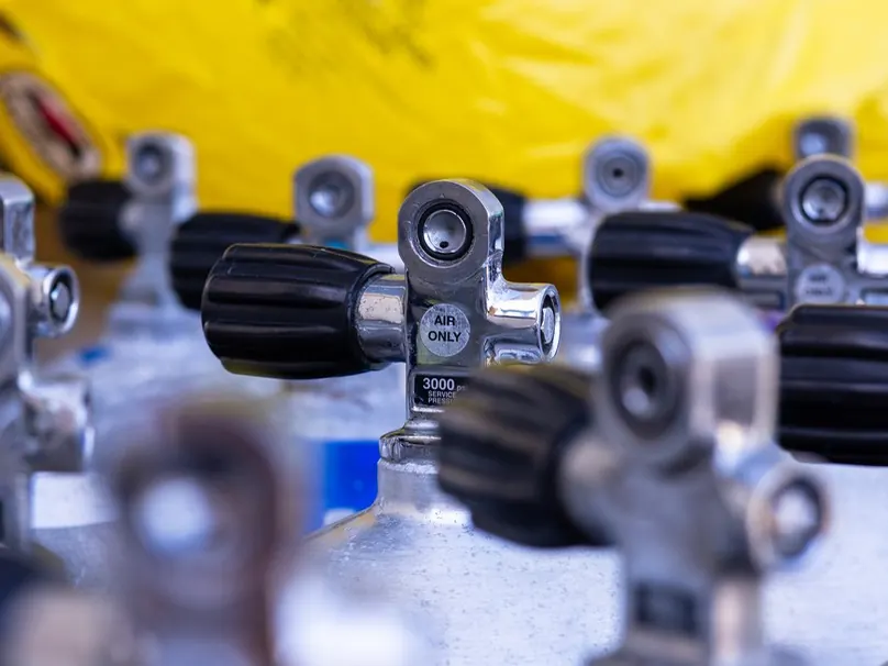 Valves on a row of compressed-air cylinders, one stamped “Air only”